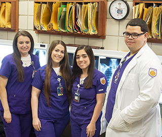 Four LSUE Students in front of X-Rays